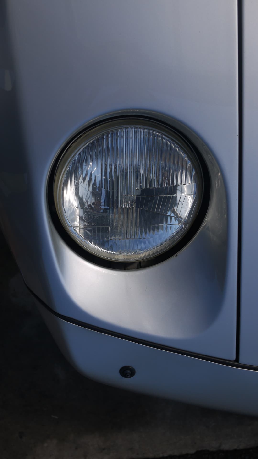 Close-up of the round Bosch headlight in the 928 front wing